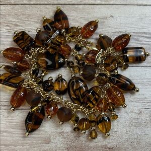 Joan Rivers charm bracelet a mix of amber glass, and tiger-eye striped art glass